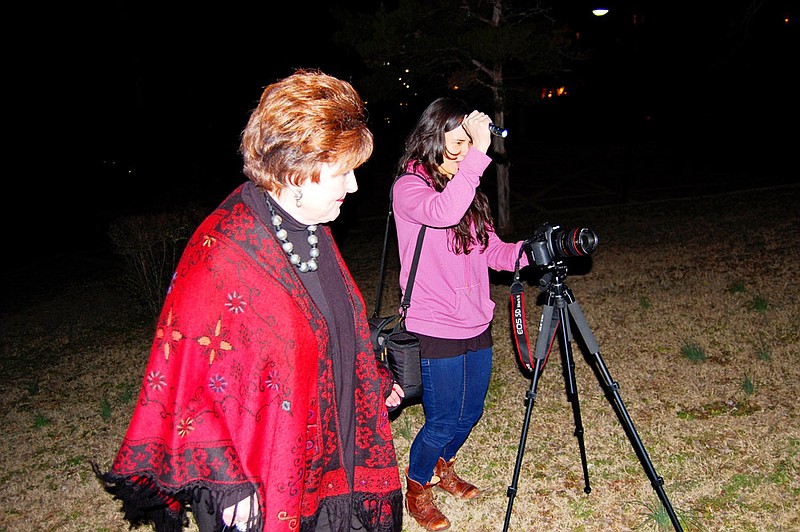 Dorothy Morris of Hot Springs, left, moves into position to have her picture taken by artist and photographer Laurel Nakadate at night on Hot Springs Mountain. After having their DNA analyzed, the two women discovered they share a common ancestor. Nakadate is traveling across the country taking photographs of her bio-cousins.