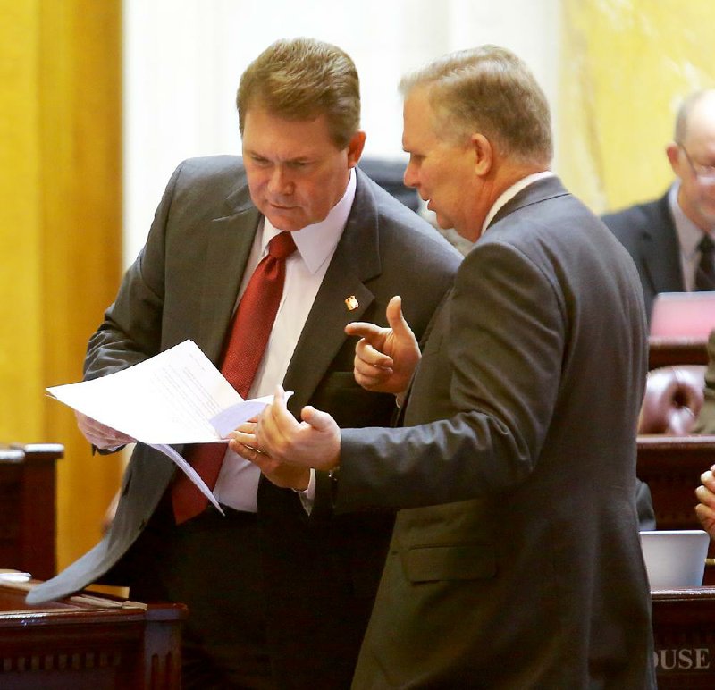 Rep. Allen Kerr, R-Little Rock, (left) and Rep. John Edwards, D-Little Rock, confer Friday at the state Capitol. House members Friday voted to create an advisory board to help plan development of a new state veterans home, a project Edwards has championed. 