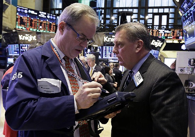 Traders David O’Day (left), and Mathias Roberts work Friday on the floor of the New York Stock Exchange. The Dow Jones industrial average passed 14,000 on Friday for the first time since Oct. 12, 2007. 