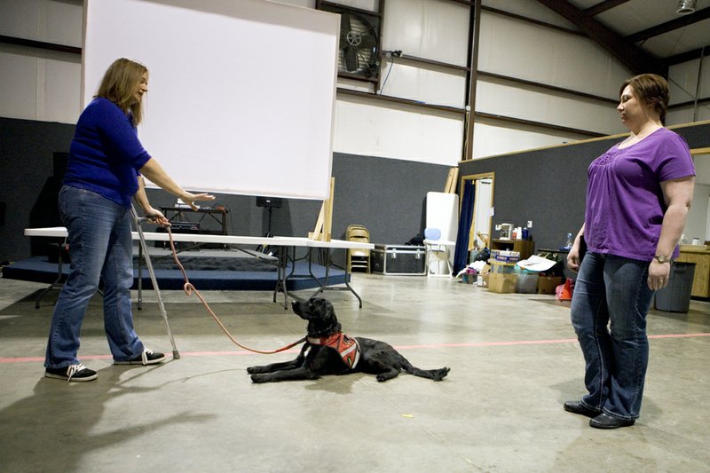 Christie Brekken, right, helps Cheri Arnold teach Molly, a service dog, to stay during a training session for A Veteran’s Best Friend. Arnold, a Desert Storm veteran who served as an Air Force medical technician, said Molly has difficulty with “stay” because she likes being right next to Arnold.