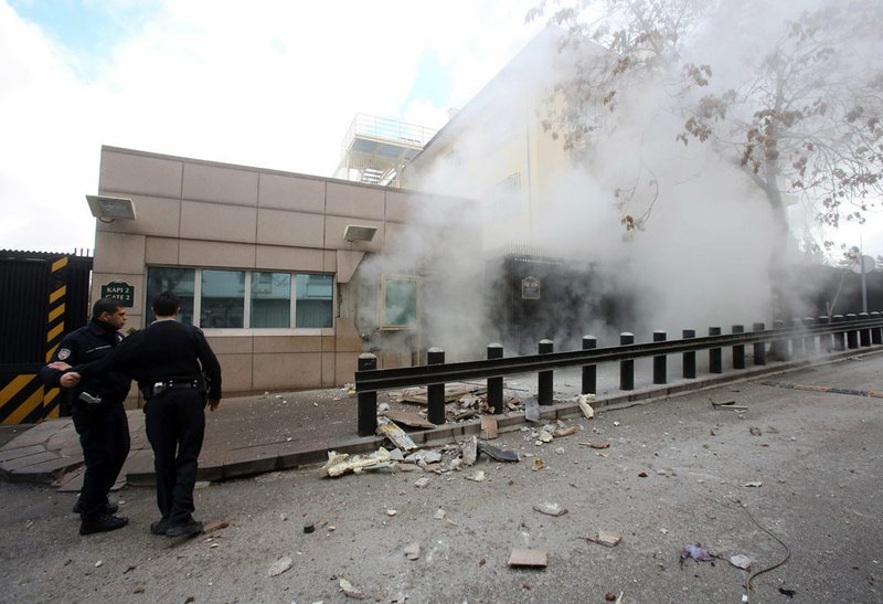 Two police officers arrive at Gate 2 of the US embassy just minutes after a suicide bomber has detonated an explosive device at the entrance of the U.S. Embassy in the Turkish capital, Ankara, Turkey, on Friday, Feb. 1, 2013.