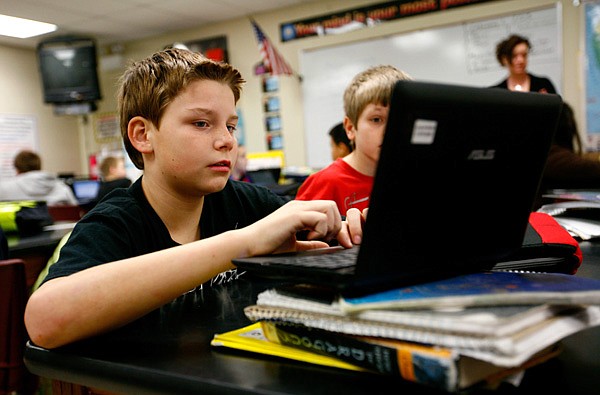 Nick Fletcher, left, and Eli Simek, both sixth-graders at Oakdale Middle School, work Friday on their science projects in Susan Tillery’s class at the Rogers school. Westside Elementary School students may have Oakdale as their destination middle school, according to the boundary plan going before the Rogers School Board Feb. 19. 