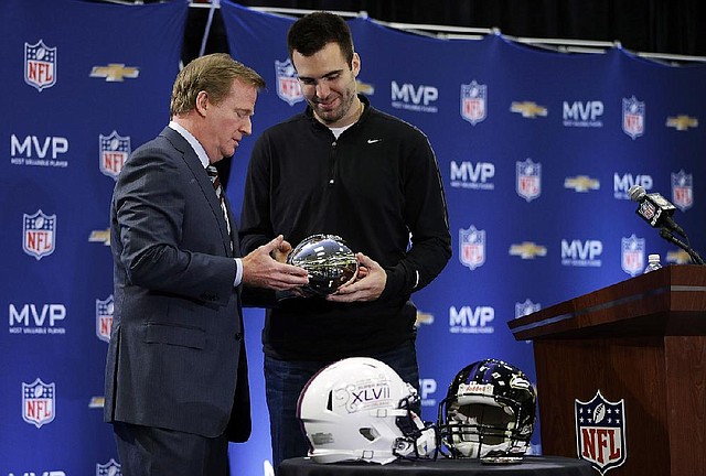 NFL Commissioner Roger Goodell (left) presents the Super Bowl MVP trophy to Baltimore Ravens quarterback Joe Flacco on Monday in New Orleans. Flacco also received a 2014 Corvette. 