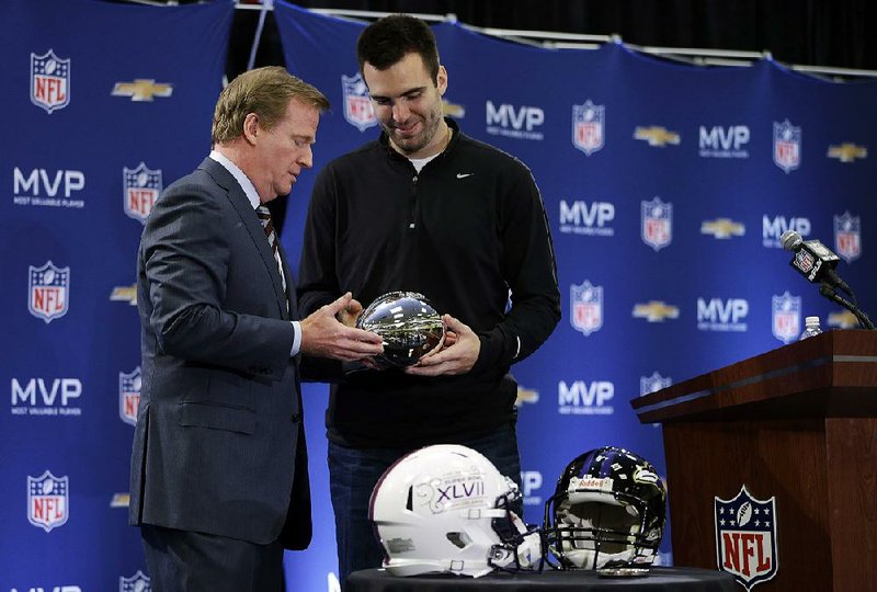 NFL Commissioner Roger Goodell (left) presents the Super Bowl MVP trophy to Baltimore Ravens quarterback Joe Flacco on Monday in New Orleans. Flacco also received a 2014 Corvette. 