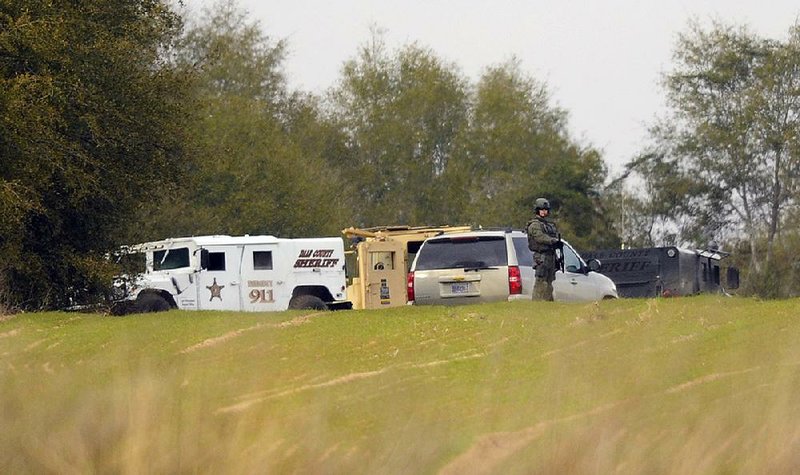 Armed law enforcement officers take up positions near the property of Jimmy Lee Dykes on Monday in Midland City, Ala. 