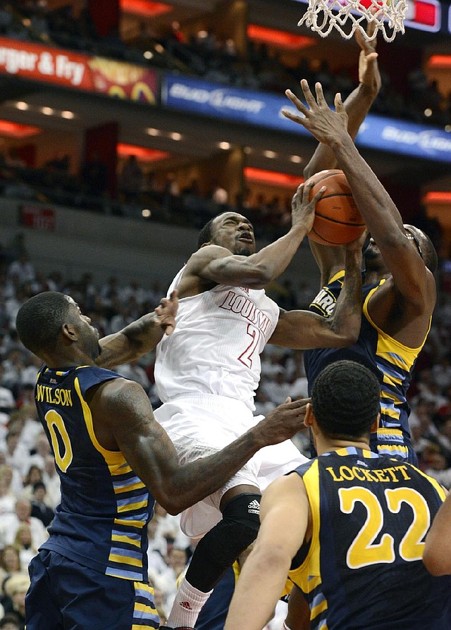 Louisville guard Russ Smith (2) fights his way to the basket past Marquette’s Trent Lockett (22) and Derrick Wilson during the second half of Sunday’s game in Louisville, Ky. Smith finished with 18 points and Louisville defeated Marquette 70-51. 