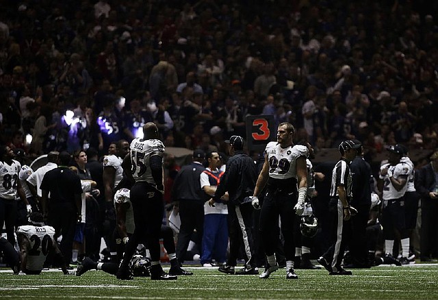 Baltimore Ravens players mill around the Superdome after the lights went out during the second half of the Super Bowl on Sunday in New Orleans. Moments after Ravens wide receiver Jacoby Jones scored on a 108-yard kickoff return, lights lining the indoor arena faded, making it difficult to see. Officials stopped play about 90 seconds into the third quarter, and the delay lasted more than 30 minutes. 