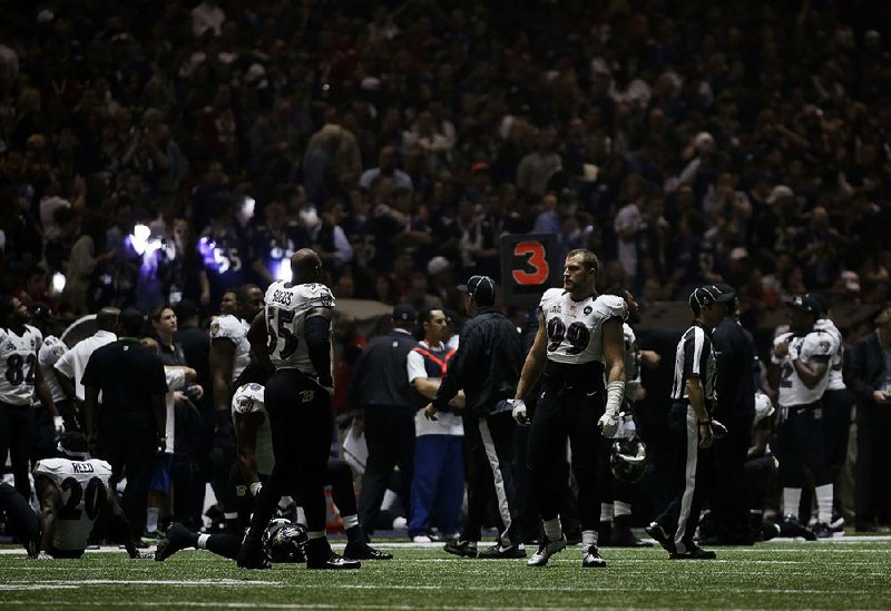 Baltimore Ravens players mill around the Superdome after the lights went out during the second half of the Super Bowl on Sunday in New Orleans. Moments after Ravens wide receiver Jacoby Jones scored on a 108-yard kickoff return, lights lining the indoor arena faded, making it difficult to see. Officials stopped play about 90 seconds into the third quarter, and the delay lasted more than 30 minutes. 