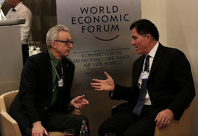 Michael Dell, chairman and chief executive officer of Dell Inc., right, speaks with a fellow delegate on day three of the World Economic Forum (WEF) in Davos, Switzerland, on Friday, Jan. 25, 2013. World leaders, influential executives, bankers and policy makers attend the 43rd annual meeting of the World Economic Forum in Davos, the five day event runs from Jan. 23-27. Photographer: Chris Ratcliffe/Bloomberg *** Local Caption *** Michael Dell