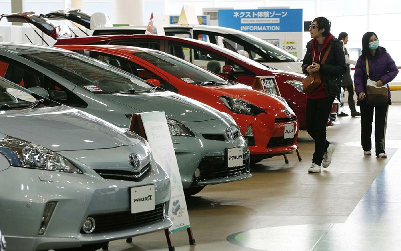 Visitors browse a Toyota showroom in Tokyo,Tuesday, Feb. 5, 2013.  Toyota Motor Corp. reported its October-December profit rose 23 percent to 99.91 billion yen ($1.09 billion), compared to the same period the previous year, as sales jumped, especially in the U.S. Toyota also raised its projections Tuesday for the fiscal year through March.  (AP Photo/Koji Sasahara)