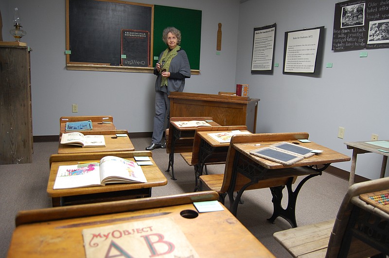 Ferrell Ford, who created the black-history exhibition at the Arkadelphia Arts Center, stands next to a teacher’s desk taken from the old Peake Elementary School, in a display reflecting school classrooms in the 1930s and ’40s. The exhibition will run at the arts center through February.   