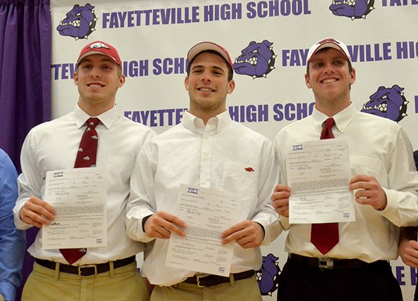 Fayetteville High students (left to right) Brooks Ellis, Alex Brignoni and Austin Allen get ready to pose for a group photo after they signed their letters of intent to play football at the University of Arkansas during the official ceremony Wednesday afternoon. 
