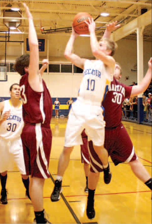 Decatur senior guard Evan Owens attempts a shot under the basket against a strong Hartford defense Jan. 25 in the Lloyd Peterson Gymnasium.