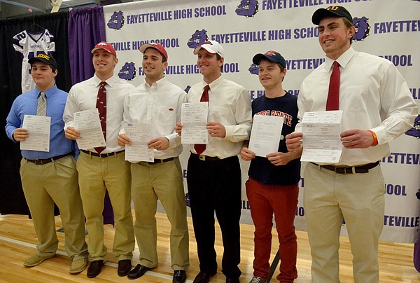 Fayetteville High students Jared Thurman, from left, Brooks Ellis, Alex Brignoni, Austin Allen, Luke Lundstrum and Chase Carney, show off their signed letters of intent after the official signing ceremony Wednesday afternoon at Fayetteville High. 