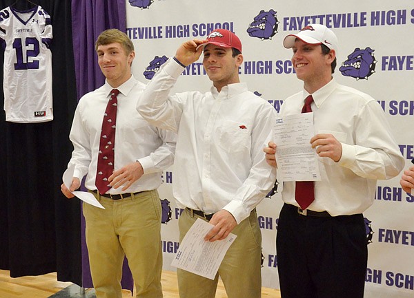 Brooks Ellis, from left, Alex Brignoni and Austin Allen, all Fayetteville High School students, pose Wednesday for a photo after they signed letters of intent to play football for the University of Arkansas. 