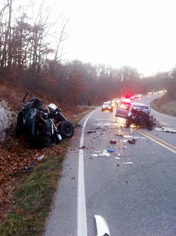 A man sets flares Wednesday morning to warn approaching traffic of a fatal accident on Arkansas 12 near Rogers. One person died in the accident. 