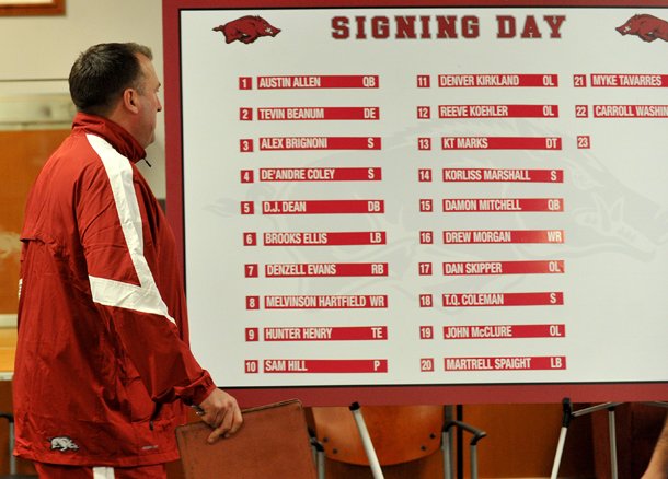 University of Arkansas head football coach Bret Bielema walks past the signing day list of 22 players who committed to the Razorbacks as he begins the press conference Wednesday afternoon in Fayetteville. 