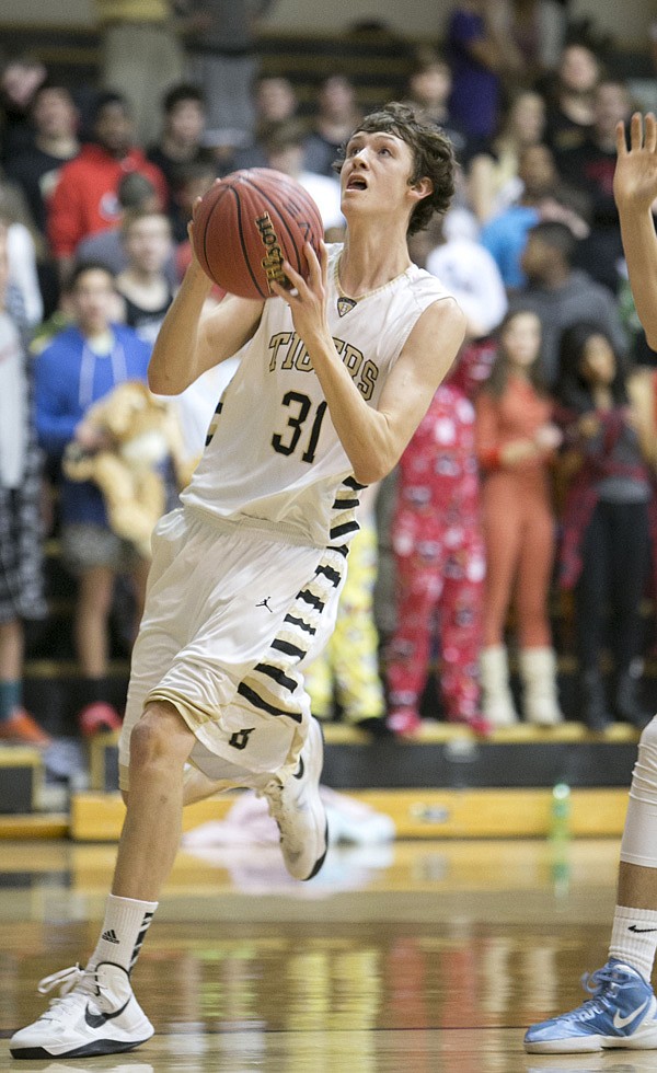 Aaron Ward of Bentonville drives to the basket on Feb. 5 during the Tigers game against Springdale Har-Ber at Bentonville. 