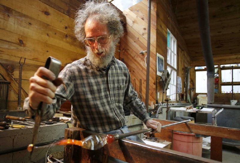 Ed Pennebaker works on a piece of a glass chandelier inside his shop in rural Carroll County. Pennebaker’s works are sold at more than a dozen galleries around the country, including in Arkansas. 