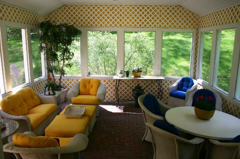 A cheery hue of yellow (No. 25 from the color bars interior designer and author Elaine Ryan created), softened with a layer of white lattice, brightens the sunroom of her home in Connecticut. 