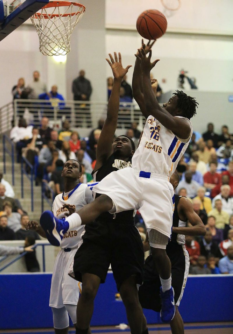 North Little Rock’s T.J. Francis (right) shoots over Jonesboro defender Aaron Washington during Friday’s game in North Little Rock. The top-ranked Charging Wildcats, led by Thomas Alexander’s 30 points and 16 rebounds, beat second-ranked Jonesboro 75-63 in a 7A/6A-East Conference game at North Little Rock Arena. 