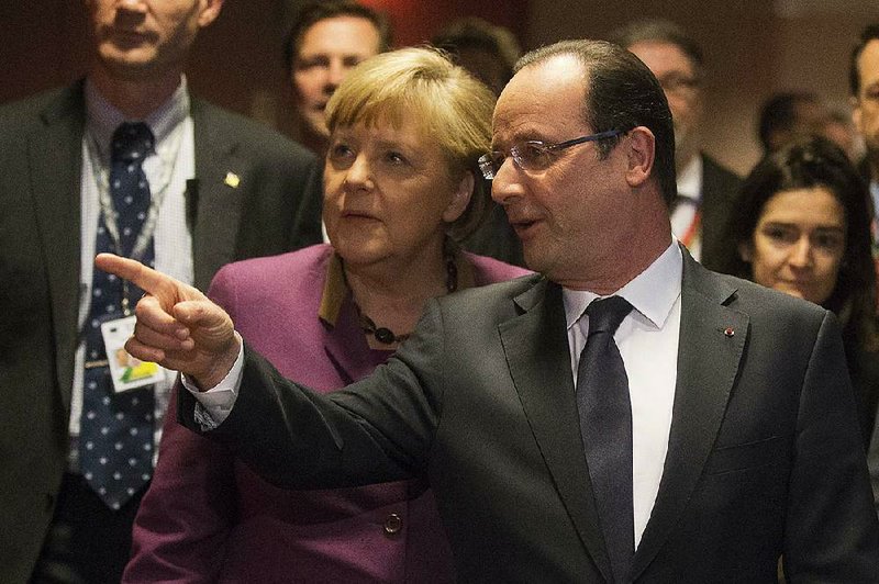German Chancellor Angela Merkel and French President Francois Hollande arrive for a news conference Friday at the conclusion of the European Union’s budget summit in Brussels. 