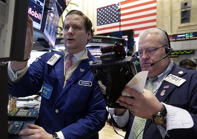 Specialist Gregg Maloney (left) and trader Tom Ferrigno work Friday on the floor of the New York Stock Exchange. 