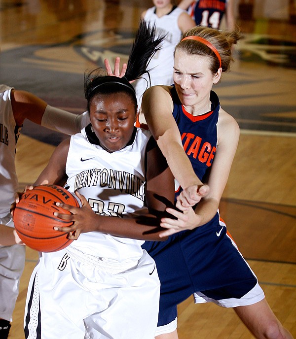 Bentonville’s Jamayne Potts, left, is fouled by Rogers Heritage senior Ellen Lundy as she pulls down a defensive rebound during the second half on Friday at Bentonville. 