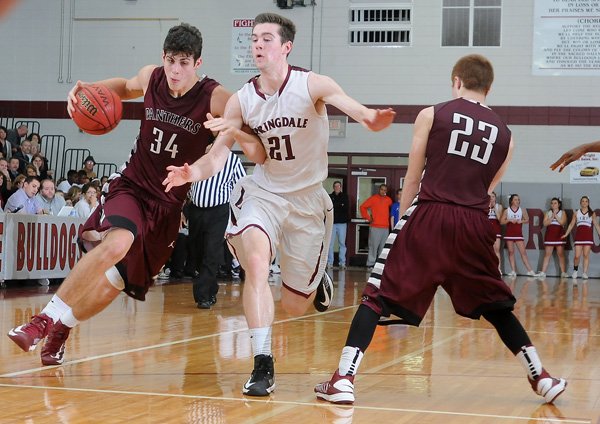 Alex Scharlau, center, of Springdale High School gets tangled up with Siloam Springs’ Payton Henson, left, while avoiding Austin Comiskey in the second half of Friday’s game at Bulldog Gymnasium in Springdale. 