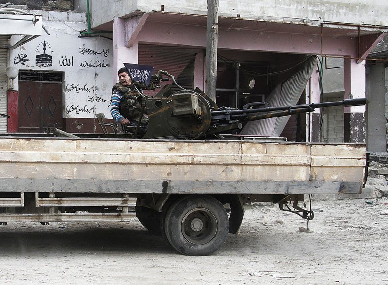 In this Friday February 8, 2013 photo, a Free Syrian Army fighter sits behind his antiaircraft machine gun in Aleppo, Syria. Syrian rebels brought their fight within a mile of the heart of Damascus on Friday, seizing army checkpoints and cutting a key highway with a row of burning tires as they pressed their campaign for the heavily guarded capital, considered the likely endgame in the nearly 2-year-old civil war.