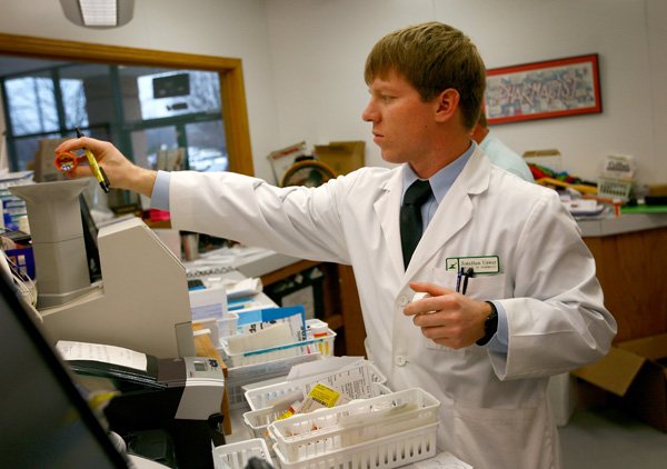 Jonathan Unwer counts pills behind the counter at North Hills Fayetteville Collier Drug Store. Unwer is a fourth-year pharmacy student at University of Arkansas for Medical Services in Fayetteville. 
