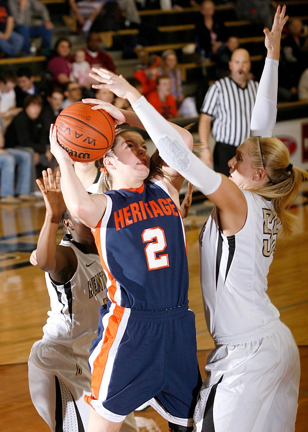 Bentonville senior Julia Garrad (right) defends a shot by Rogers Heritage senior Ashley Ward during the second half on Friday, Feb. 8, 2013, at Bentonville High School.