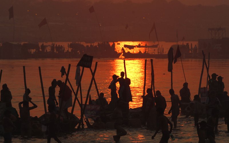 Hindu devotees pray against a setting sun, after a holy dip at 'Sangam', the confluence of Hindu holy rivers Ganges, Yamuna and the mythical Saraswati, during the Maha Kumbh festival at Allahabad, India, Sunday, Feb. 10, 2013. Led by heads of monasteries arriving on chariots and ash-smeared naked ascetics, millions of devout Hindus plunged into the frigid waters of the holy Ganges River in India on Sunday in a ritual that they believe will wash away their sins. Sunday was the third of six auspicious bathing days during the Kumbh Mela, or Pitcher Festival, which lasts 55 days and is one of the world's largest religious gatherings.