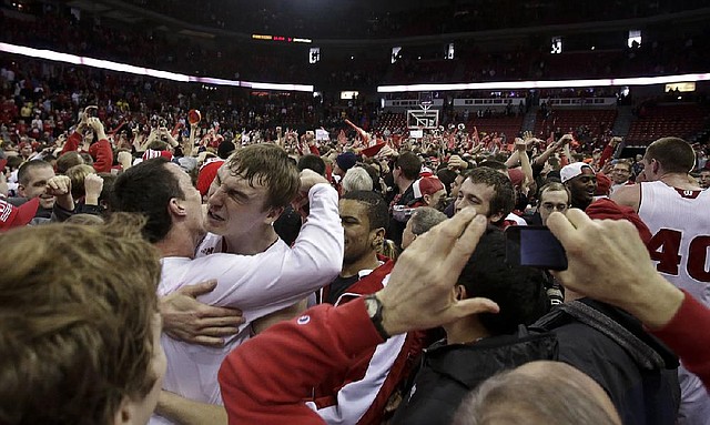 Wisconsin’s Sam Dekker celebrates with teammate Dan Fahey (far left) after Wisconsin upset No. 3 Michigan 65-62 on Saturday in Madison, Wis. The top three teams in The Associated Press Top 25 men’s basketball poll (Indiana, Florida, Michigan) all lost in the past week. Indiana lost at Illinois on Thursday while Florida fell at Arkansas on Tuesday. 