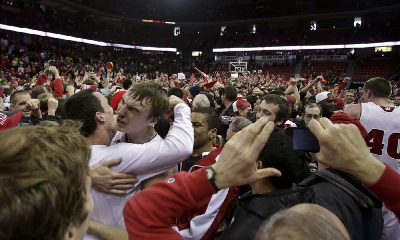 Wisconsin’s Sam Dekker celebrates with teammate Dan Fahey (far left) after Wisconsin upset No. 3 Michigan 65-62 on Saturday in Madison, Wis. The top three teams in The Associated Press Top 25 men’s basketball poll (Indiana, Florida, Michigan) all lost in the past week. Indiana lost at Illinois on Thursday while Florida fell at Arkansas on Tuesday. 