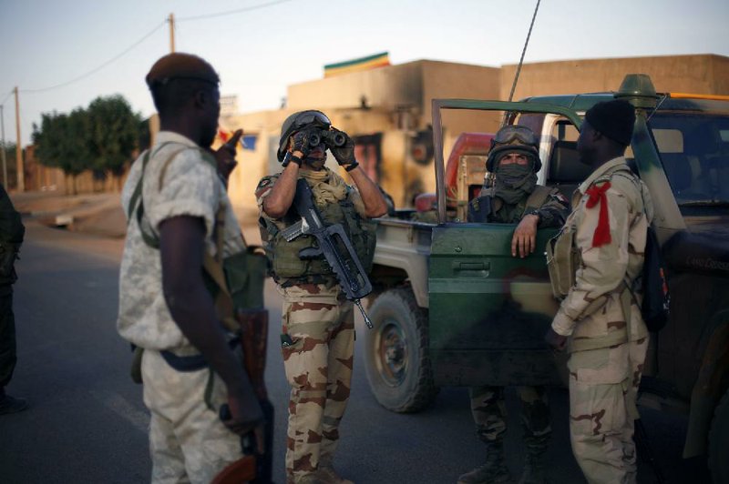 French and Malian soldiers check for snipers during exchanges of fire with jihadists Sunday in Gao, Mali. 