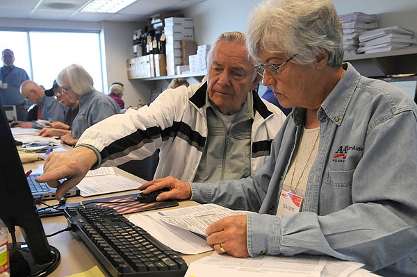 Walter Gaspord, left, gets help with his tax return from Claudine Barnett, an AARP volunteer tax preparer. Business was brisk on Wednesday for tax assistance at the Rogers Activity Center.