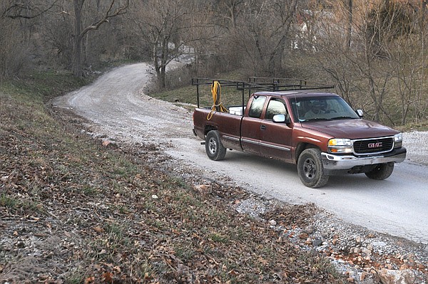 A driver travels on Puppy Creek Road Friday as it turns from a dirt road to a paved road in Springdale. The city plans to pave all remaining dirt roads in city limits including a stretch that heads north to Lowell. 