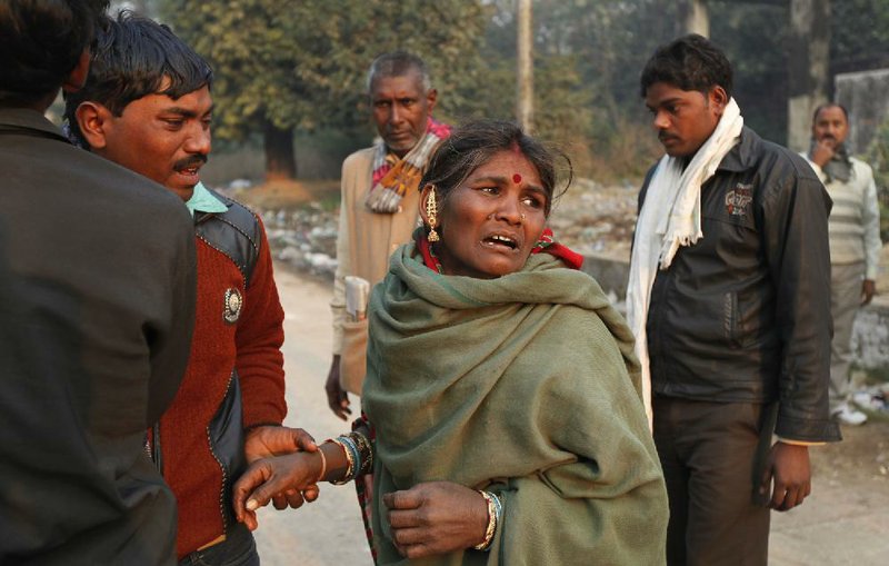 An Indian woman cries outside a morgue as she arrives to take the body of her daughter Monday in Allahabad, India. 