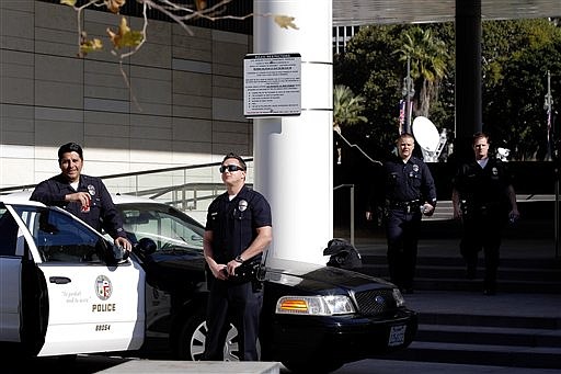 Los Angeles police officers stand alert at the LAPD headquarters in Los Angeles on Tuesday, Feb. 12, 2013. Police are now investigating more than 1,000 tips from the public in the search for the Christopher Dorner, who is suspected of a deadly revenge plot against the Los Angeles Police Department. The number of tips has grown from an initial 250 since the city offered a $1 million reward for information leading to the capture of Dorner. 