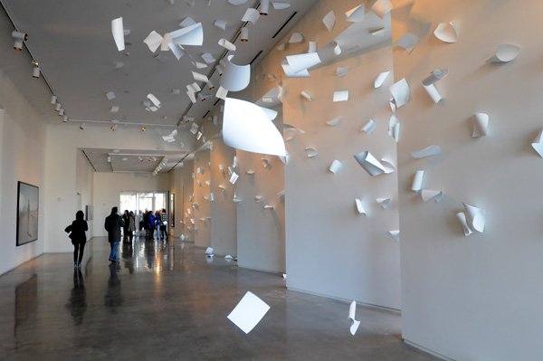 Attendees of the 21c Museum Hotel opening walk past the site-specific instillation A Sudden Gust of Wind by Serkan Ozkaya on Monday in downtown Bentonville. The hotel hosts 104 rooms and 12,000 square feet of multipurpose museum space for 21st century art. The hotel opened with two exhibits that will be changed twice a year, and eight permanent site-specific installations. The Bentonville location is the third 21c Museum Hotel to open. The Bentonville location is the third 21c Museum Hotel to open. 