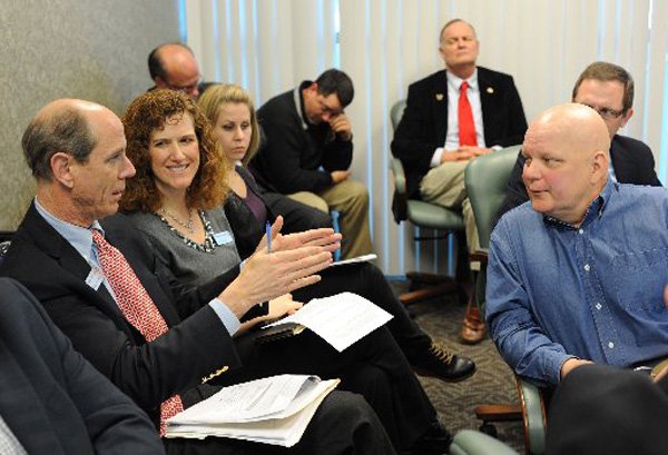 Peter Lane, president and CEO of the Walton Arts Center, left, and Bob Davis, member of the Fayetteville Advertising and Promotion Commission, right, exchange ideas Monday, Feb. 11, 2013, during a meeting of the commission at the Fayetteville Town Center. Beside Lane is Terri Trotter, chief operating officer of the arts center, and Beth Bobbitt, public relations manager for the center.