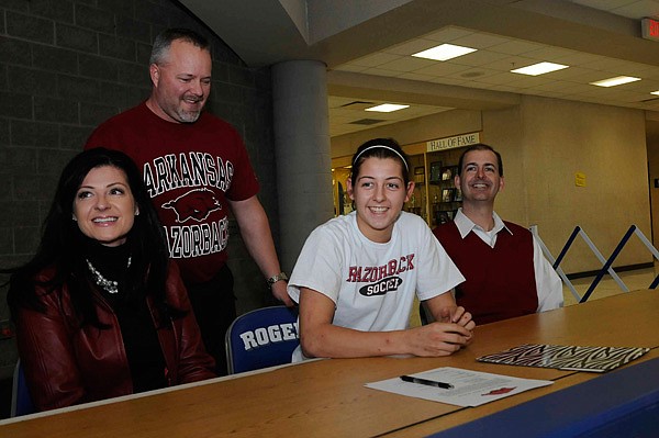 McKinzie James, second from right, signed a national letter of intent to play soccer for the Arkansas Razorbacks on Tuesday with her mom, Stephanie James, from left, Rogers soccer coach Steve Peck and her dad, Matt James. 