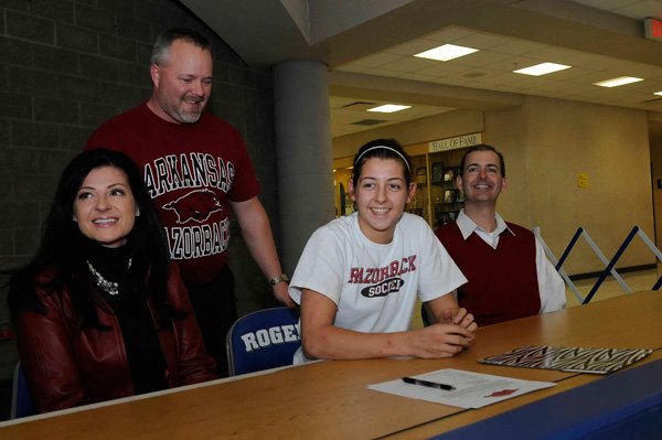 McKinzie James, second from right, signed a national letter of intent to play soccer for the Arkansas Razorbacks on Tuesday with her mom, Stephanie James, from left, Rogers soccer coach Steve Peck and her dad, Matt James. 