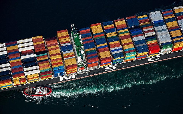 A tugboat helps guide a Mediterranean Shipping Co. (MSC) ship loaded with freight containers in this aerial photograph approaching the Port of Long Beach in Long Beach, California, U.S., on Friday, Feb. 1, 2013. The U.S. Census Bureau is scheduled to release trade balance figures on Feb. 8. Photographer: Tim Rue/Bloomberg