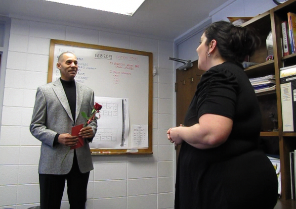 Brad Montgomery listens to a rendition of "Till There Was You" sung by Susej Thompson Thursday morning after being surprised with the singing Valentine's Day telegram at work.