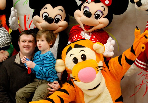 Max Rogers, 4, and his father, Brian Rogers, pose for photos Wednesday with Disney characters on at Rogers High School. Max, who has been diagnosed with leukemia, and his family were honored with a week trip to Walt Disney World through the Make-A-Wish Foundation. The high school’s Deca group raised $5,000 to help pay for the wish. 