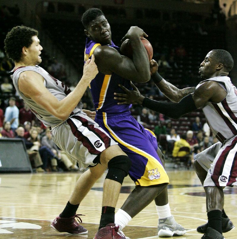 LSU’s Johnny O’Bryant (center) drives to the basket against South Carolina’s Michael Carrera (left) and Bruce Ellington during the second half of the Tigers’ 64-46 victory over the Gamecocks on Thursday in Columbia, S.C. O’Bryant had a career-high 30 points and 10 rebounds for the Tigers. 