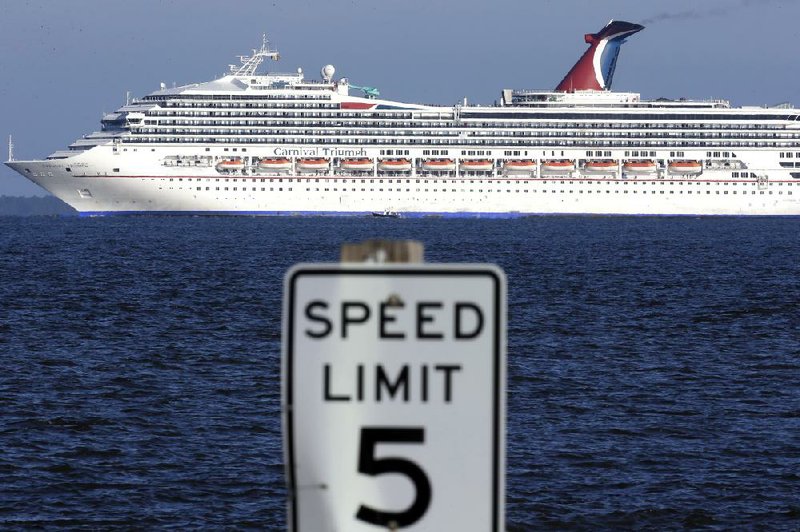 The cruise ship Carnival Triumph is towed at a snail’s pace Thursday into Mobile Bay, Ala., where its more than 4,200 passengers eagerly waited to disembark. 