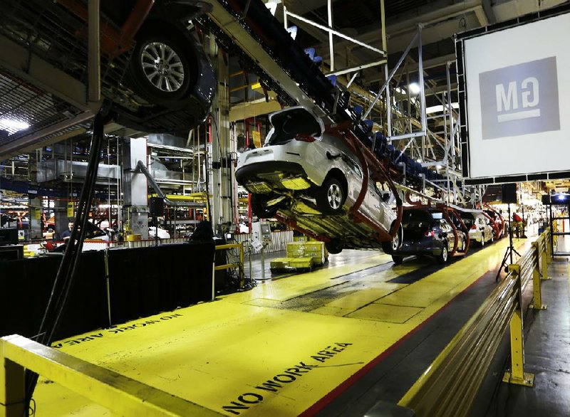 The assembly line is in full swing last month at the General Motors Fairfax plant in Kansas City, Kan. The automaker posted fourth-quarter gains in the U.S. and Asia, but losses in Europe. 